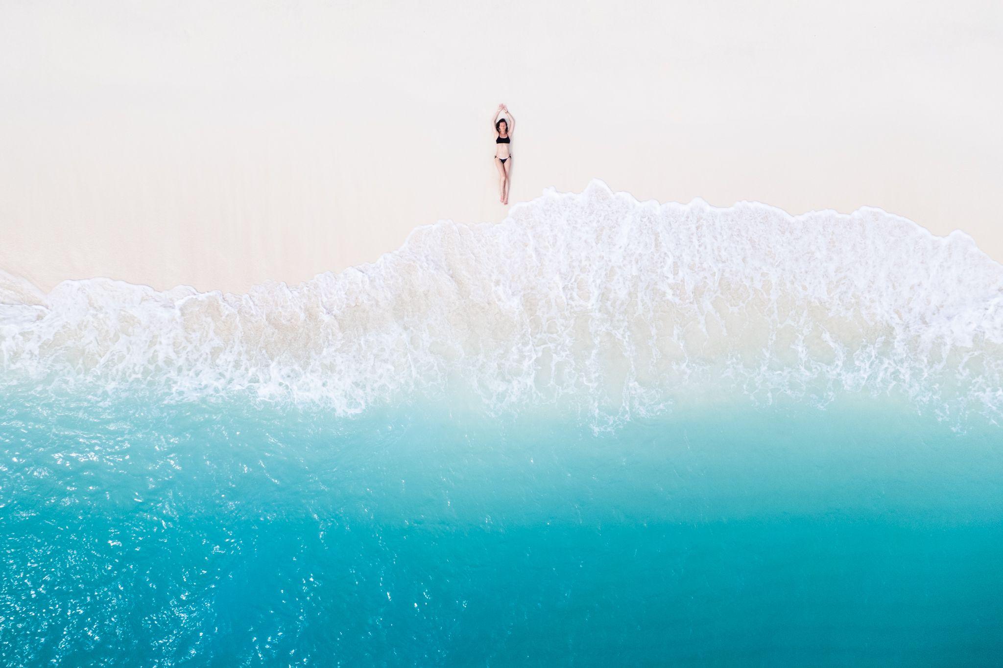 A model on the beach with blue waters in front